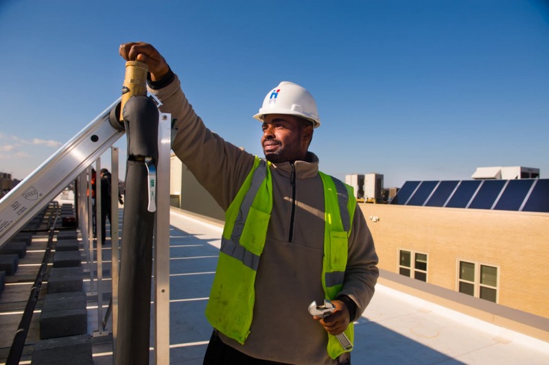 Solar technician adjusting solar panels on a roof